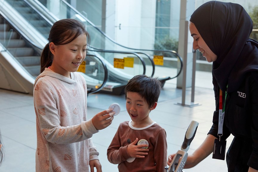 Children take part in a badge making activity. 