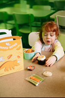 A child eating a dino bites cupcake.