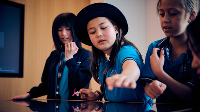 A group of students in the Road to Zero Learning Studio interacting with a touch table 