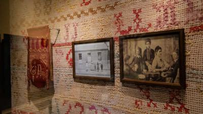 Black and white phots of immigrant families in  Voices Across Time exhibition at the Immigration Museum.