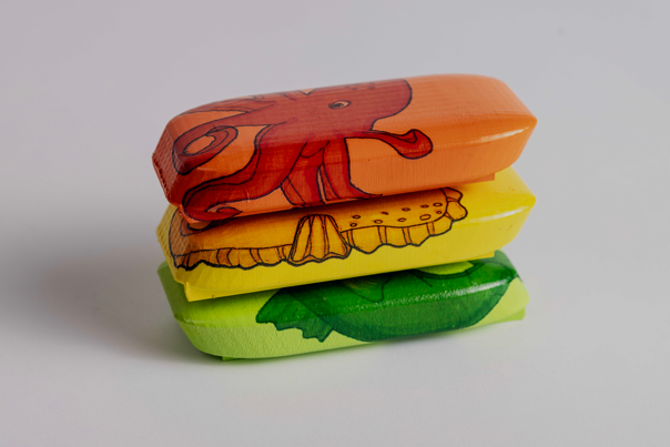 Stack of three flotational devices in orange, yellow and green.