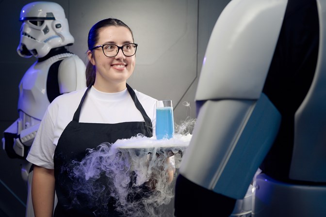 Woman in an apron serves blue milk on a smoking platter to a stormtrooper.