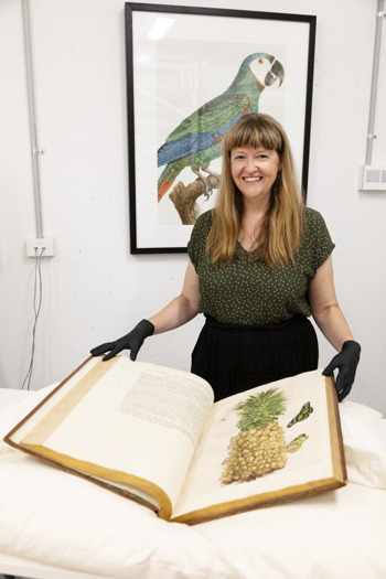 Museum Library staff member, Hayley Webster (Manager Library), viewing a rare book within the Rare Book Collection Store.