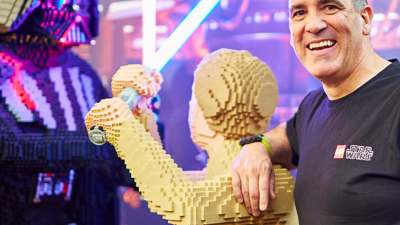 LEGO® Certified Professional Ryan ‘Brickman’ McNaught stands with his creation of Luke Skywalker fighting Darth Vadar at Lego Star Wars Exhibition.