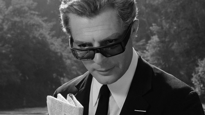 Close up portrait of a man wear a suit sunglasses and holding a newspaper