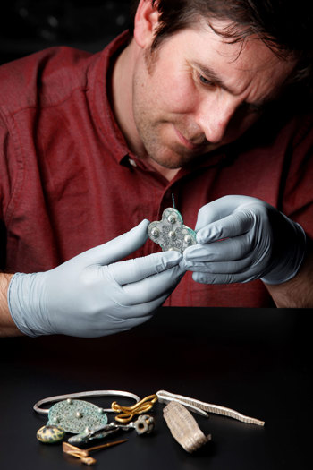 Dr Martin Goldberg wears gloves while inspecting a broach found in the Galloway Hoard.