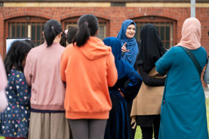 Presenter and participants doing 'cloud' activities outside as part of the workshop.