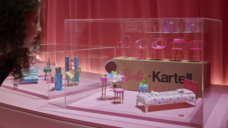 A display of barbie accessories showing a bed, dressing table and various chairs.
