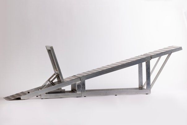 Steel-toned metal ramp for BMX practice starts, featuring a hinged perpendicular support and textured surface for traction.