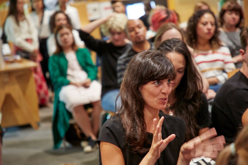 Audience member participates in a discussion at a panel talk event.  