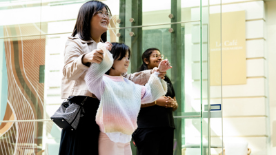 An adult and child dancing to a performance at Immigration Museum.