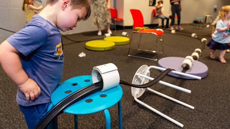 Father and son constructing their roller coaster at the Kinder Coaster activity in the Energy LAB at Scienceworks, Little Kids Day In on 8th December 2023.