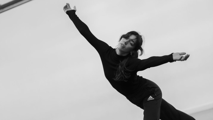 Arianna is dancing with her arms wide open.