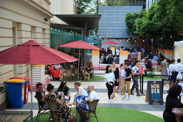 People socialising at the Immigration Museum in the outdoor courtyard.