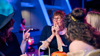 A woman dressed as a witch presses a love-shaped Jello to her mouth.