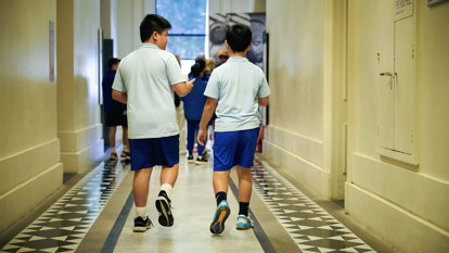 Two students walking through a corridor at the Immigration Museum on a school excursion.  