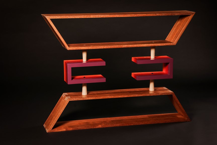 Geometric wooden shelving unit with purple and red feature pieces in the centre.