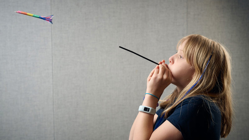 A young adult fires a blow-dart  during a Science Studio workshop at Scienceworks.