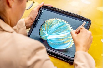 A close-up of someone outlining key details of a seashell on a tablet during Digital Art Class at Melbourne Museum.