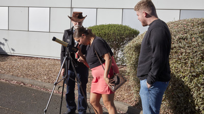 People enjoying the Valentine's Day themed events at Scienceworks, with staff providing a view of the skies with telescope.