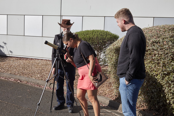 People enjoying the Valentine's Day themed events at Scienceworks, with staff providing a view of the skies with telescope.