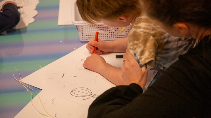 Child drawing on paper in the Kinder Clubhouse at Scienceworks.