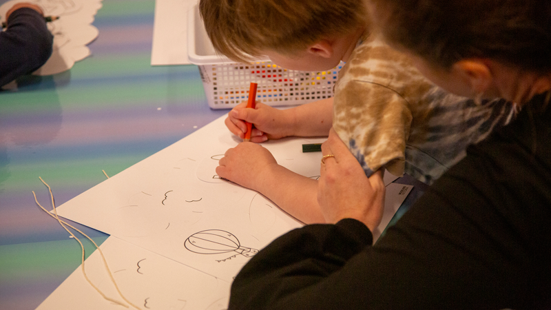 Child drawing on paper in the Kinder Clubhouse at Scienceworks.
