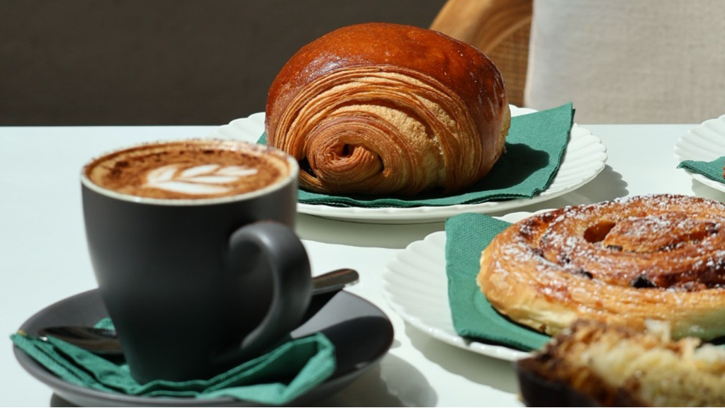 Cappuccino in a mug with a pain au chocolat and escargot