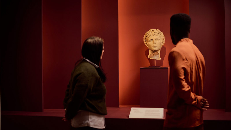 Visitors viewing a roman bust ROME: Empire, Power, People exhibition in Melbourne Museum.