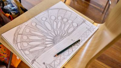 A closeup of a sketch book where someone has drawn the iconic half-circle window of the Royal Exhibition Building.