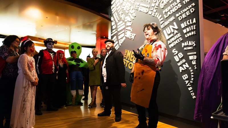 A museum tour guide dressed as a bloody butcher talks to audiences about horrible histories during Halloween at the Museum.
