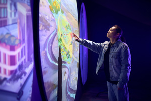 Person uses an interactive display inside Our Wonderous Planet exhibition at Melbourne Museum.