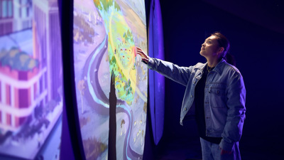 Person uses an interactive display inside Our Wonderous Planet exhibition at Melbourne Museum.