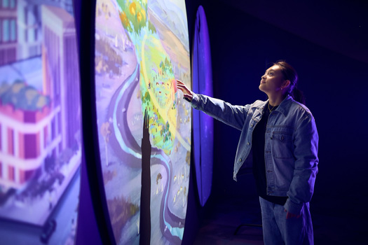 Person uses an interactive display inside Our Wonderous Planet exhibition at Melbourne Museum.