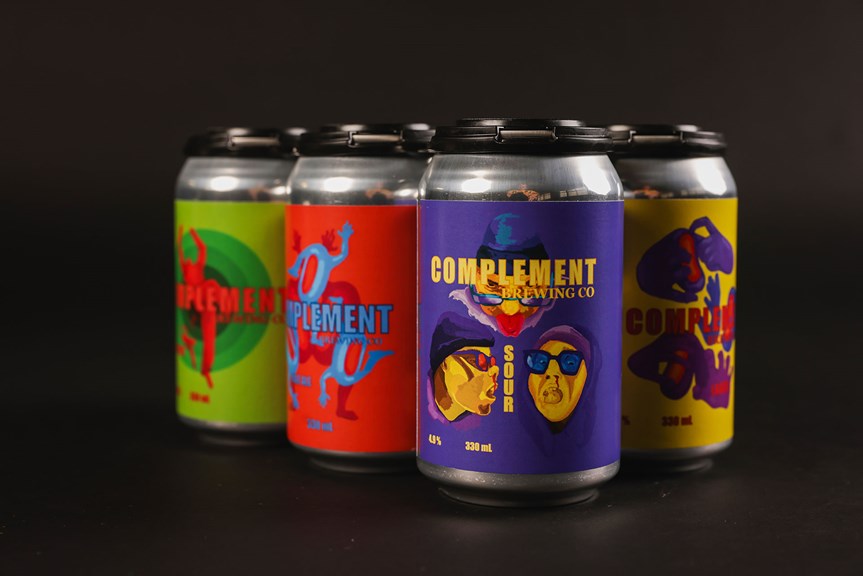 Four aluminum beer cans with different coloured graphic labels.