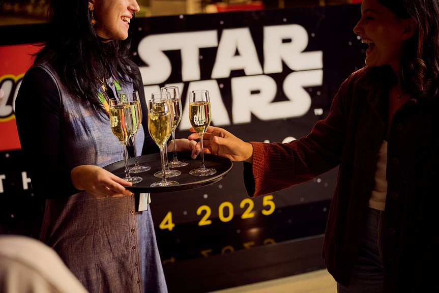 Museum guests are served glasses of champagne while attending LEGO Star Wars Exhibition during Adult Museum Sleepovers at Melbourne Museum.
