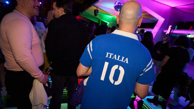 The back of  person wearing a Italian football jersey at Discoteca Italiana, Melbourne Museum.