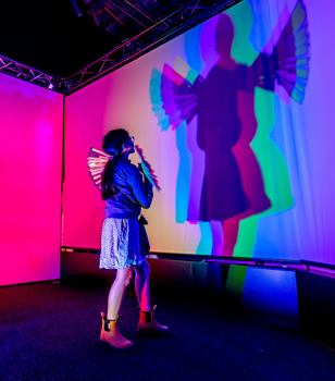 A child playing with shadows at Illuminate exhibition.