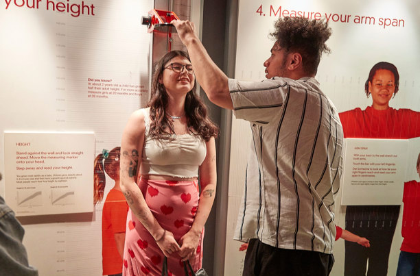 People enjoying the Valentine's Day themed events at Scienceworks, take time to measure heights.