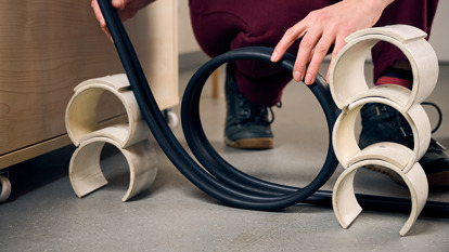 A student’s hands, holding a rubber strip in a loop to make a model rollercoaster track during an education program at Scienceworks.