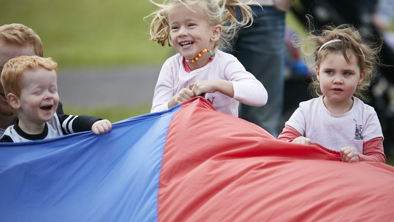 Kids enjoying playing with a parachute 