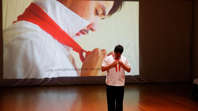 a man in white doing up his red tie