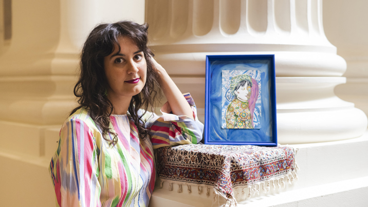 Kate Robinson posing next to her art