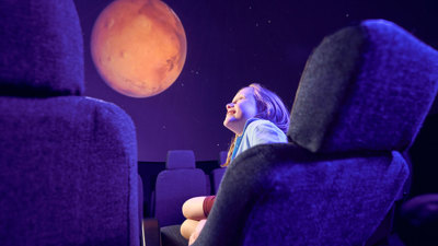 A primary school student observes a projection of Mars on the dome of the Melbourne Planetarium