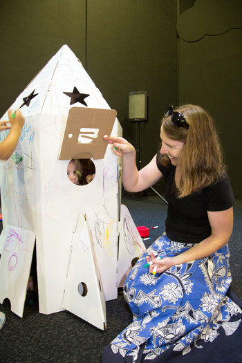 Mother and child playing with a carrdboard rocket at Little Kids Day In event in Scienceworks