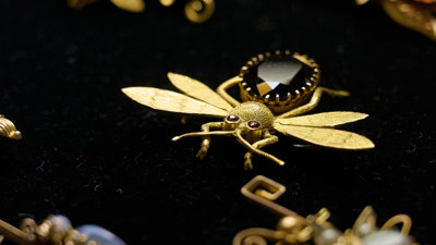 Pieces of gold jewellery laid out on black felt fabric.