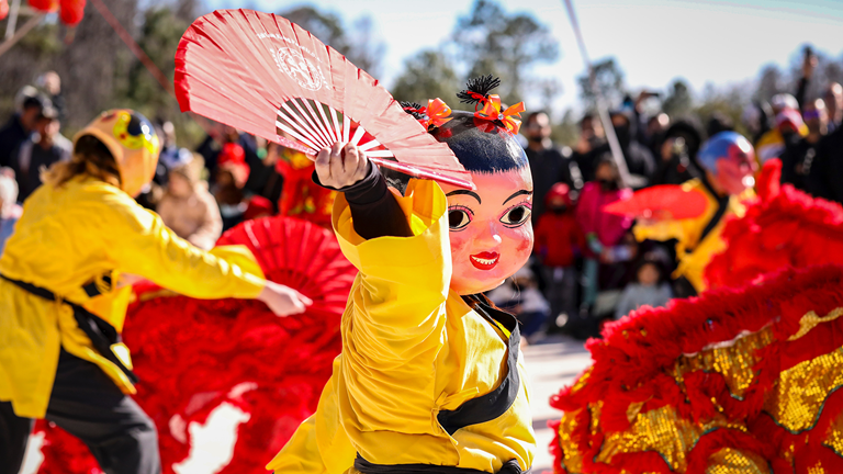 Audiences enjoy a traditional Lunar New Year performance by dragon and fan dancers..