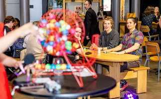 A bingo wheel is turned as seated players look on.