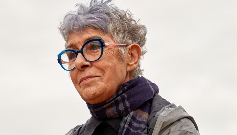 Close up portrait of older woman with large blue glasses wearing a scarf