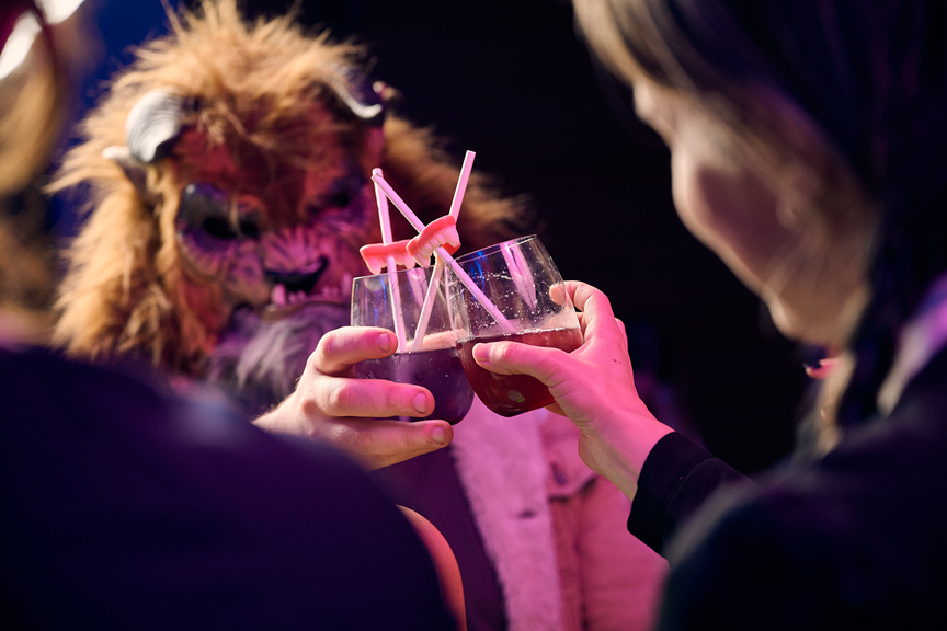 The Beast and Wednesday Adams cheers a cocktail.